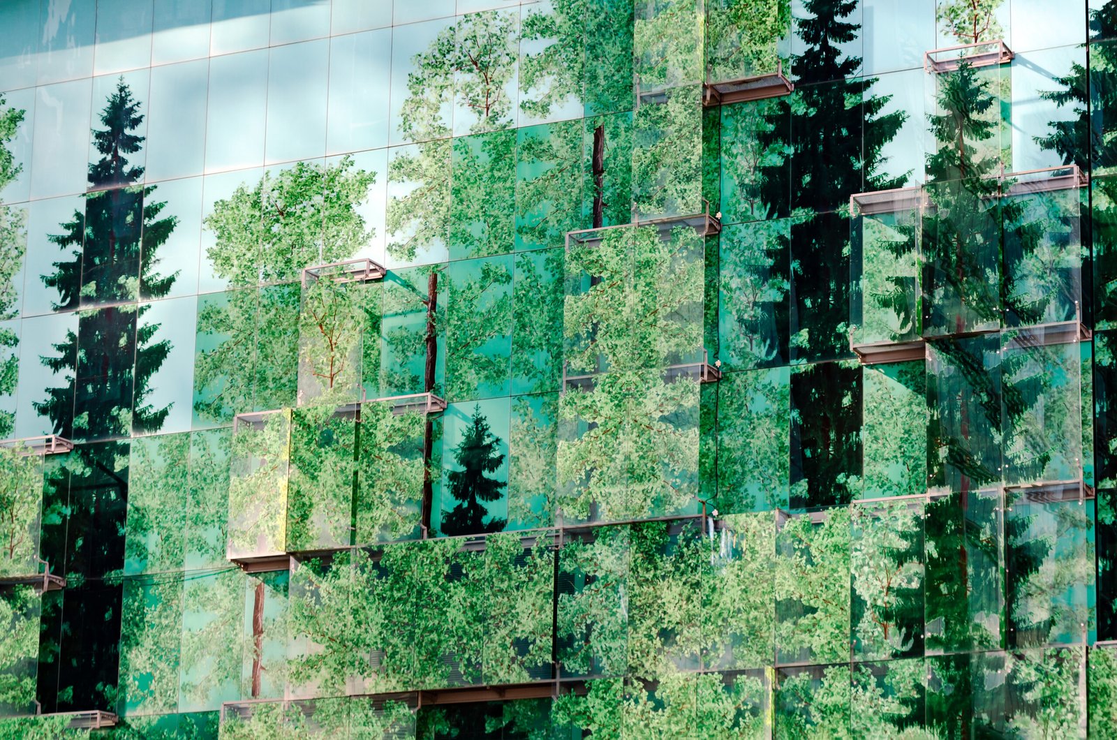 glass facade with trees printed on it. combining nature with architecture. The reflective surface of the structure reflects the essence of the urban environment